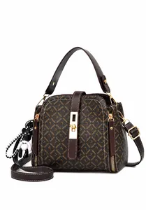 Dettaglio della borsa a secchiello monogram marrone con hardware dorato e ciondolo a orsetto