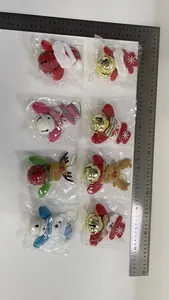 Detailed view of various plush Christmas ornaments with bells and measurement ruler