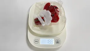 Christmas Santa Claus plush ornament with red bell on a digital scale weighing 18.8g