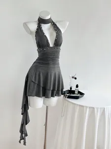 Vestido corto sexy gris con cuello halter sin mangas y tachuelas plateadas en un maniquí