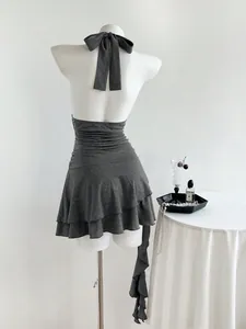 Vista posterior detallada de un minivestido gris de volantes con cuello halter sin mangas