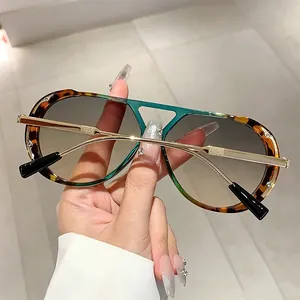 Detail of retro sunglasses with leopard print frames and golden metal temples.