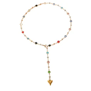 Close-up detail of golden stainless steel Y-necklace with colorful stones and heart pendant