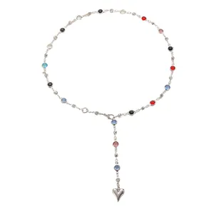 Detailed view of silver heart pendant and colorful zircon stones on stainless steel necklace