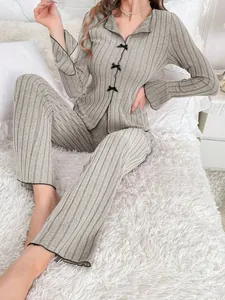 Cozy women's grey ribbed knit two-piece pajama set with chic bow details and flared cuffs