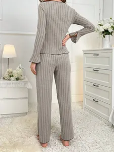 Detailed back view of a grey ribbed long sleeve pajama set with bell cuffs in a room