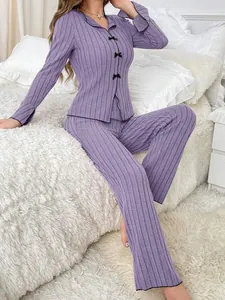 Detail of purple ribbed two-piece pajama set with elegant black bow accents.