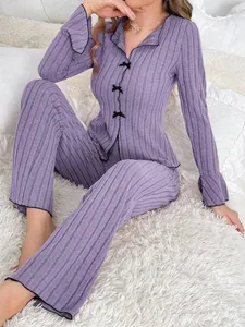 Detailed shot of a purple ribbed two-piece pajama set with decorative black bows.