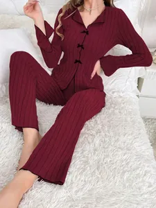 Close-up view of a wine red ribbed two-piece pajama set featuring elegant bow button details
