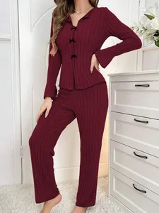 Elegant women's burgundy ribbed two-piece pajama set with decorative bow accents