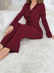 Close-up detail of women's burgundy ribbed loungewear set with elegant black bow accents