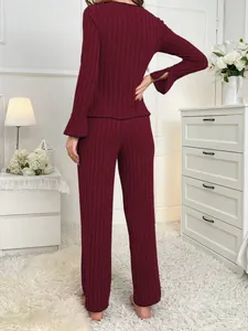 Back view of women's burgundy ribbed pajama set in a cozy home setting