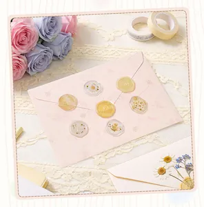 Macro detail of semi-transparent floral wax seal stickers on a pink envelope.