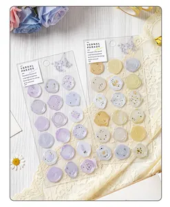 Macro view of translucent purple and cream faux wax seal stickers with floral patterns