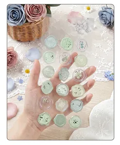 Detailed view of translucent floral wax seal stickers held against soft background