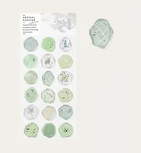 Makroansicht und ganzer Bogen grüner, halbtransparenter Wachssiegel-Sticker mit Blumen