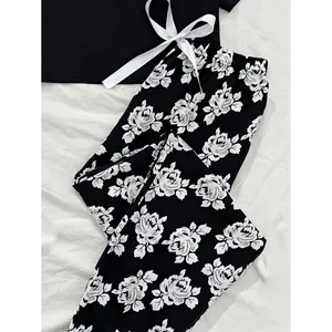 Elegant women's black short sleeve pajama set with white rose floral long pants