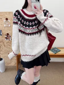 Detail view of an oversized Fair Isle knit sweater with red and white festive Christmas patterns