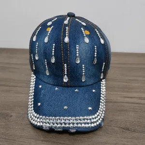 Dettaglio di un cappello da baseball in denim blu con strass a forma di goccia d'acqua