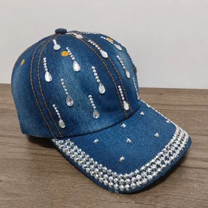 Dettaglio del cappellino da baseball in denim con strass a goccia luccicanti