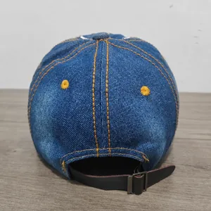 Vista dettagliata del retro di un berretto da baseball in denim blu con cinturino in pelle