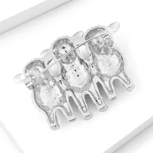 Detailed back view of a silver-colored three-sheep brooch with a secure metal pin fastener