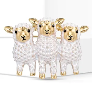 Detailed view of a cute three-sheep animal brooch with white enamel and gold finish