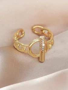 Detail of gold-plated open ring featuring a crystal-encrusted OT buckle design