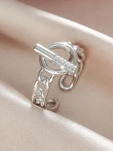 Detailed macro view of silver chain ring featuring micro-pave zircon toggle on pink silk