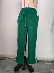 Women's green high-waisted wide-leg sweatpants featuring contrast white side stripes and drawstrings