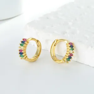 Détail macro de créoles dorées serties de zircons multicolores de taille baguette