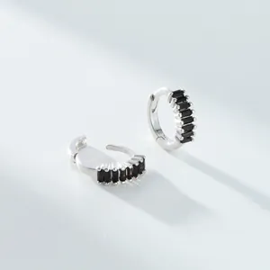 Détail de boucles d'oreilles créoles en argent serties de zircons noirs taille baguette