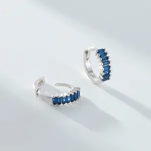 Vue macro de boucles d'oreilles créoles en argent 925 avec pierres bleues baguette