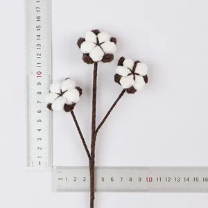 Close-up of handmade knitted cotton flower branch with rulers showing weight and dimensions.