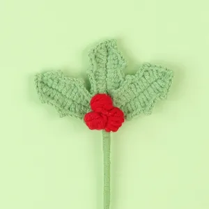 Close-up of handmade crochet holly leaves and red berries Christmas decoration
