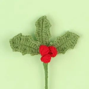 Detailed view of handmade crochet Christmas holly leaves and berries decoration.