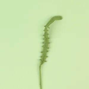 Detailed view of handmade green knitted leaf stem for Christmas bouquet