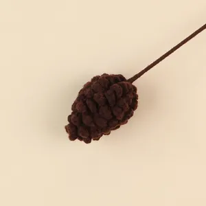 Detailed view of a handmade brown crochet pinecone decoration for DIY Christmas floral bouquets