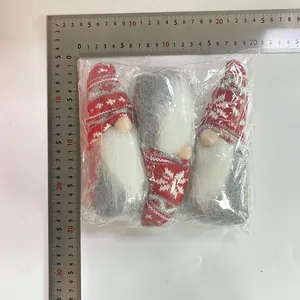 Detail view of three Christmas gnome plush dolls in package with measuring ruler