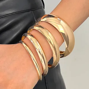 Close-up detail of stacked vintage golden bangles with a polished smooth surface finish