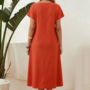 Detailed back view of a burnt orange cotton-linen short-sleeve maxi dress in a studio setting