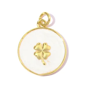 Vue macro détaillée d'un pendentif rond plaqué or avec un trèfle à quatre feuilles en émail blanc.