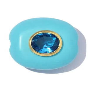 Detailansicht eines ovalen Anhängers aus Türkisstein mit blauem Zirkon in 18k Goldfassung