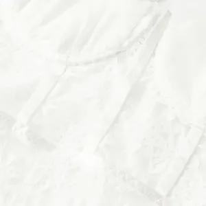 Macro detail of delicate floral lace and underwire structure on a white bodysuit