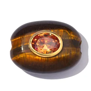 Nahaufnahme der ovalen Tigerauge-Perle mit facettiertem orangefarbenem Zirkon