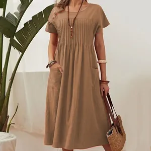 Close-up view of a brown cotton linen dress showing round neck and pleated details