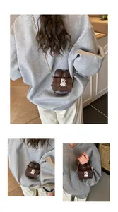 Close-up detail of a mini brown bow-shaped crossbody coin purse with a cartoon bear