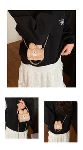 Detail view of mini cartoon crossbody bag with elegant bow and stylish gold chain strap