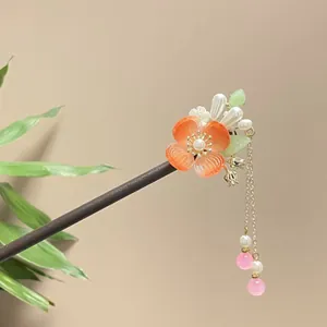 Elegant handmade sandalwood hair stick with orange floral detail and pink tassels