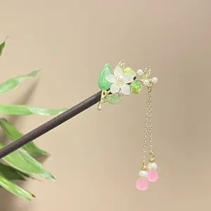 Detailed view of a vintage wooden hair stick with white flower and pink bead tassels